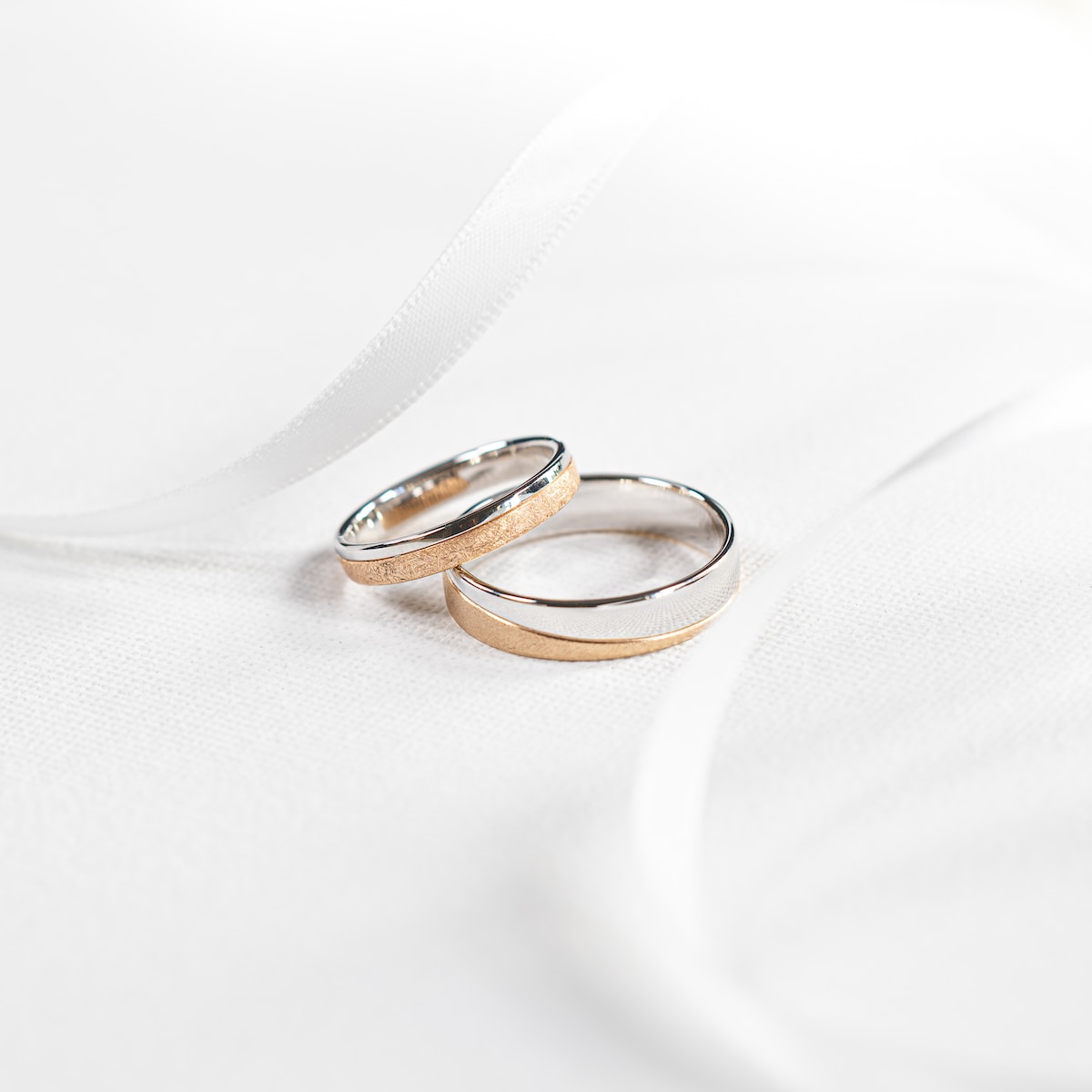 deux bagues mariage posées sur un tissu blanc