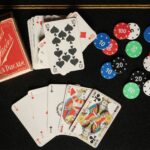 Une table noire surmontée de cartes à jouer et de jetons