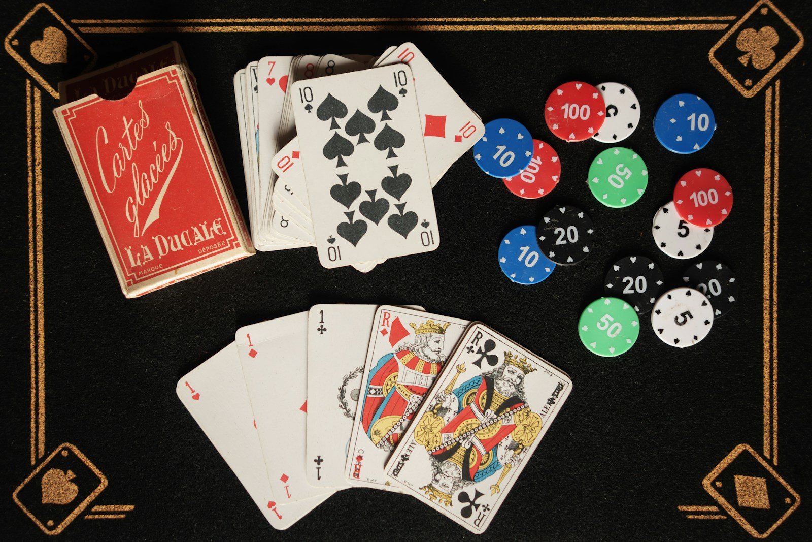 Une table noire surmontée de cartes à jouer et de jetons